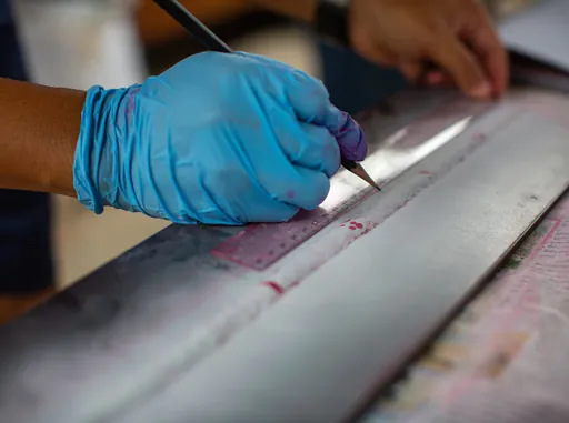 Gloved hand marking a surface during repair and prep work
